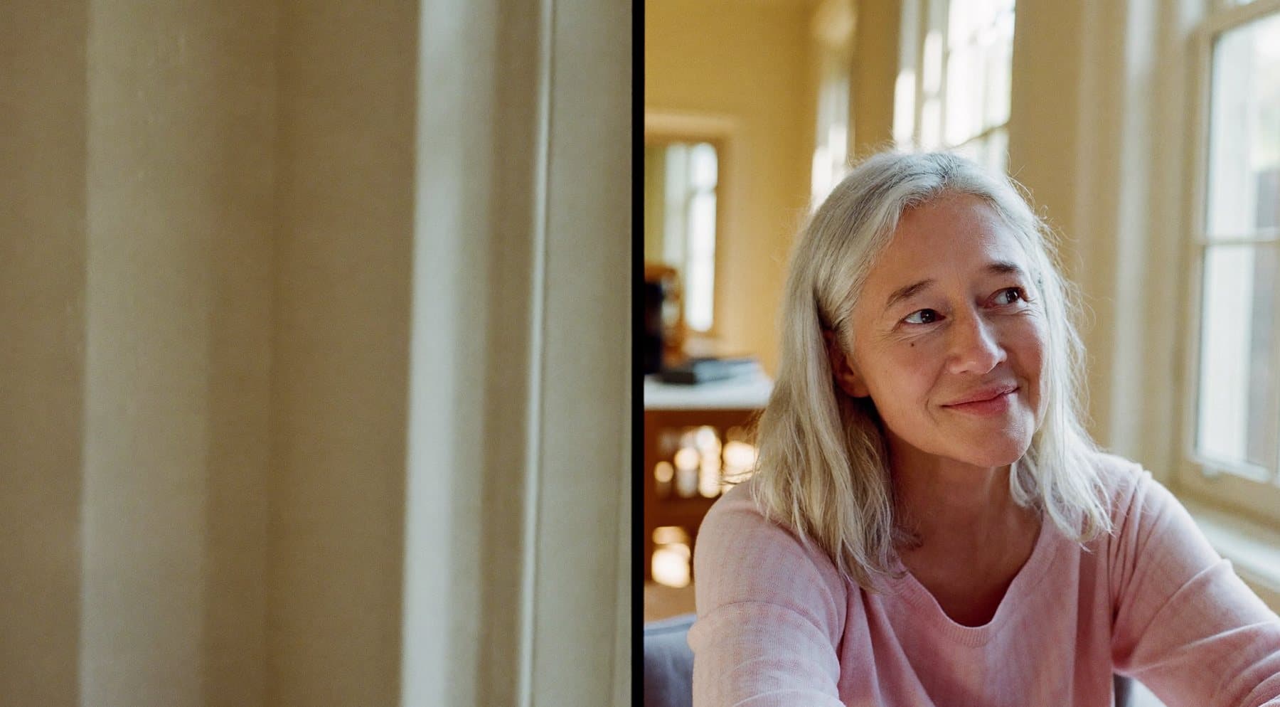 A silver-haired woman at home in soft morning light