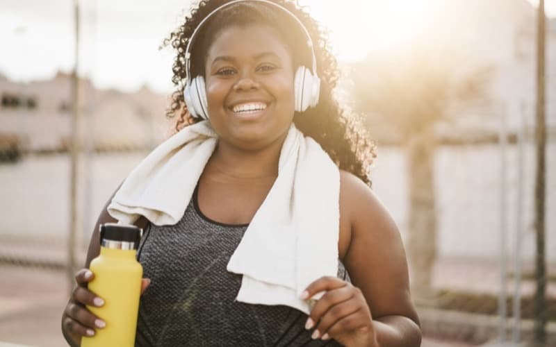A woman mid-workout at golden hour, towel over her shoulders