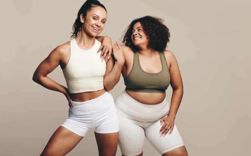 Two women in activewear laughing together after training