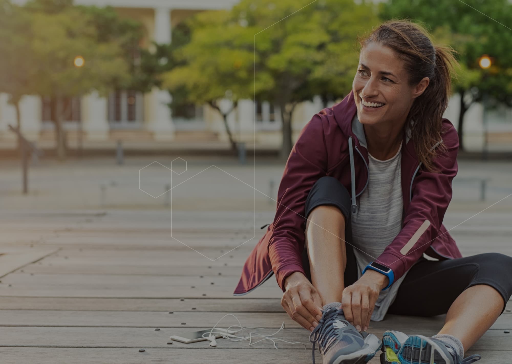 A woman running at golden hour with a wearable band on her wrist